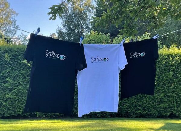 Three different T-shirts are hanging, to show the sizes and colours.